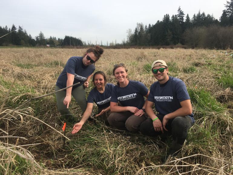 4 tree planters showing off a newly planted tree