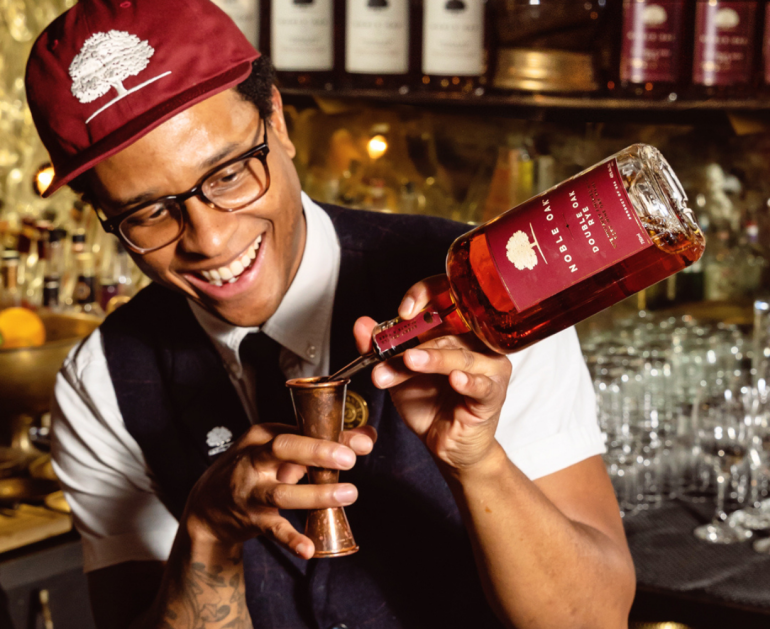 Bartender pouring Noble Oak Rye into a Jigger