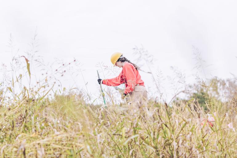 Woman digging to plant trees in Boggy Slough Area