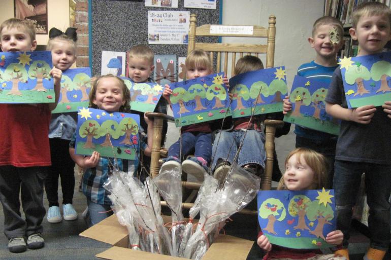 Elementary Schoolers holding up pics of trees 